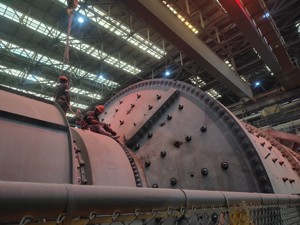 Técnicos con arnés sobre molino industrial